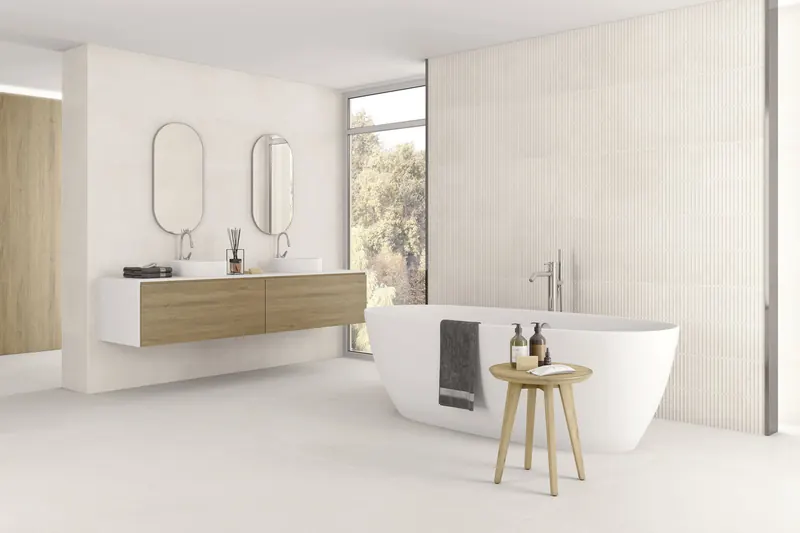 Salle de bain lumineuse carrelée en blanc avec baignoire îlot